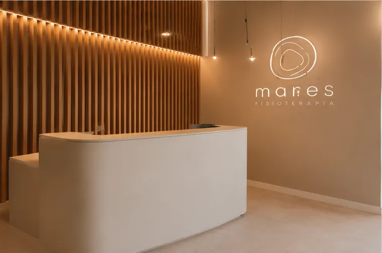 Mostrador de recepción de la clínica, con celosía de madera y el rótulo de Mares en la pared.