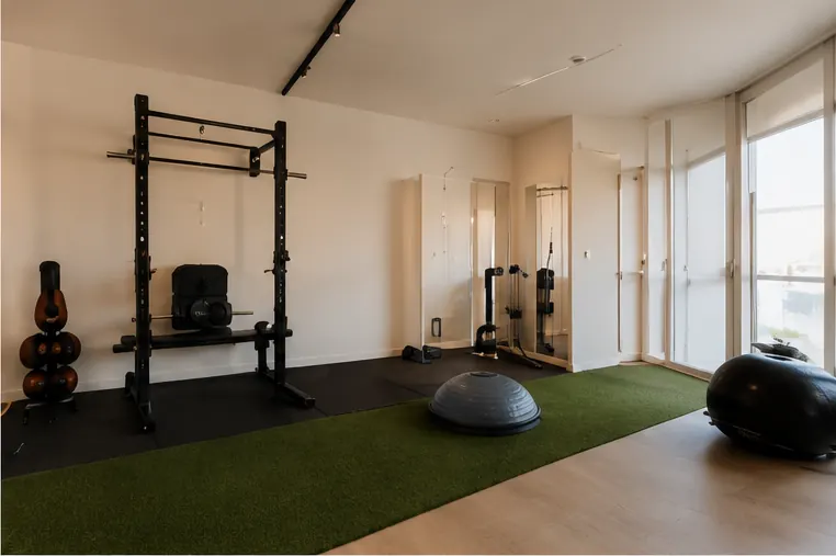 Sala de ejercicio de la clínica, con suelo de madera y material de trabajo.